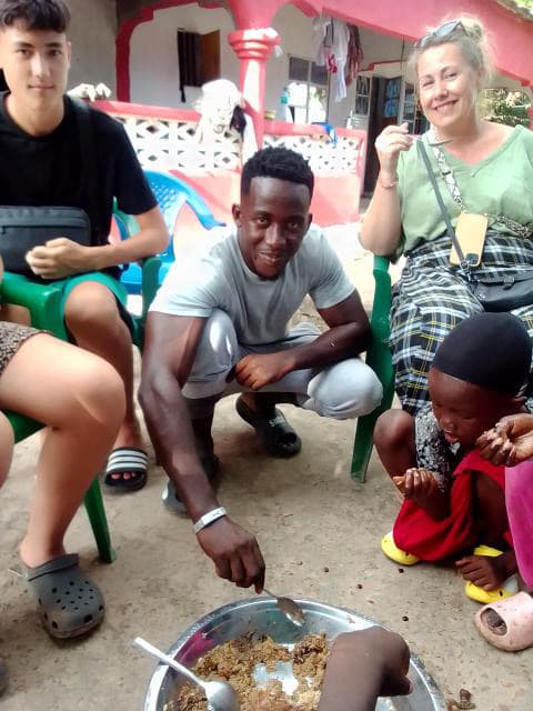 Guests sharing a local meal with their guide in The Gambia.